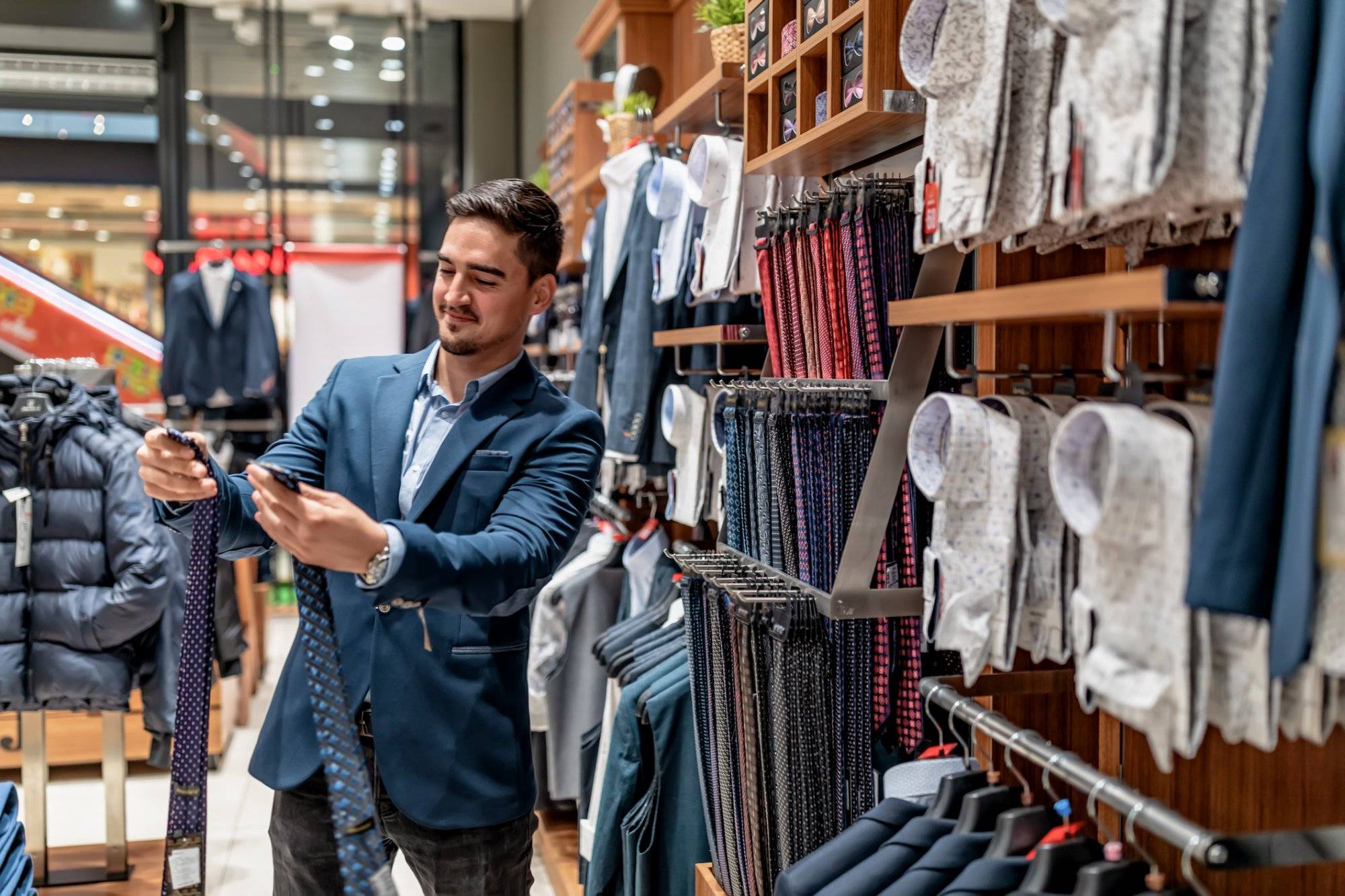 Portrait of handsome young man buying clothes in the store.